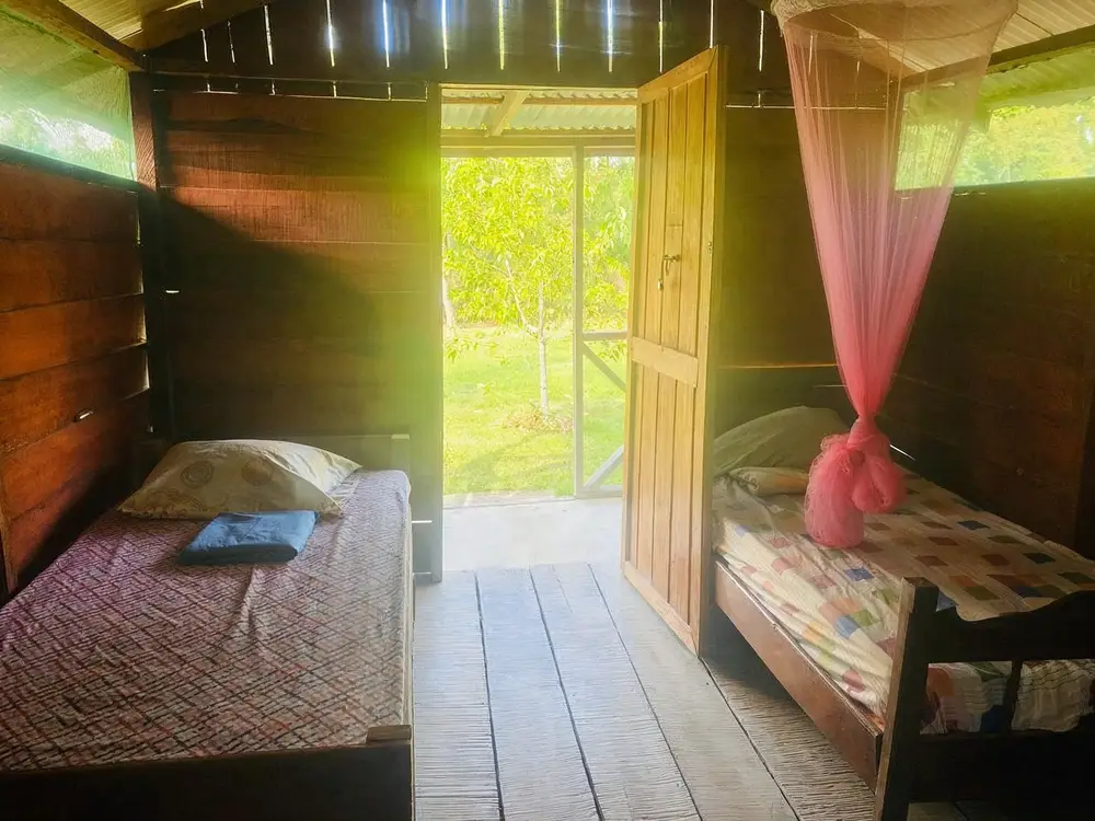 Houten kamer met bed en klamboe